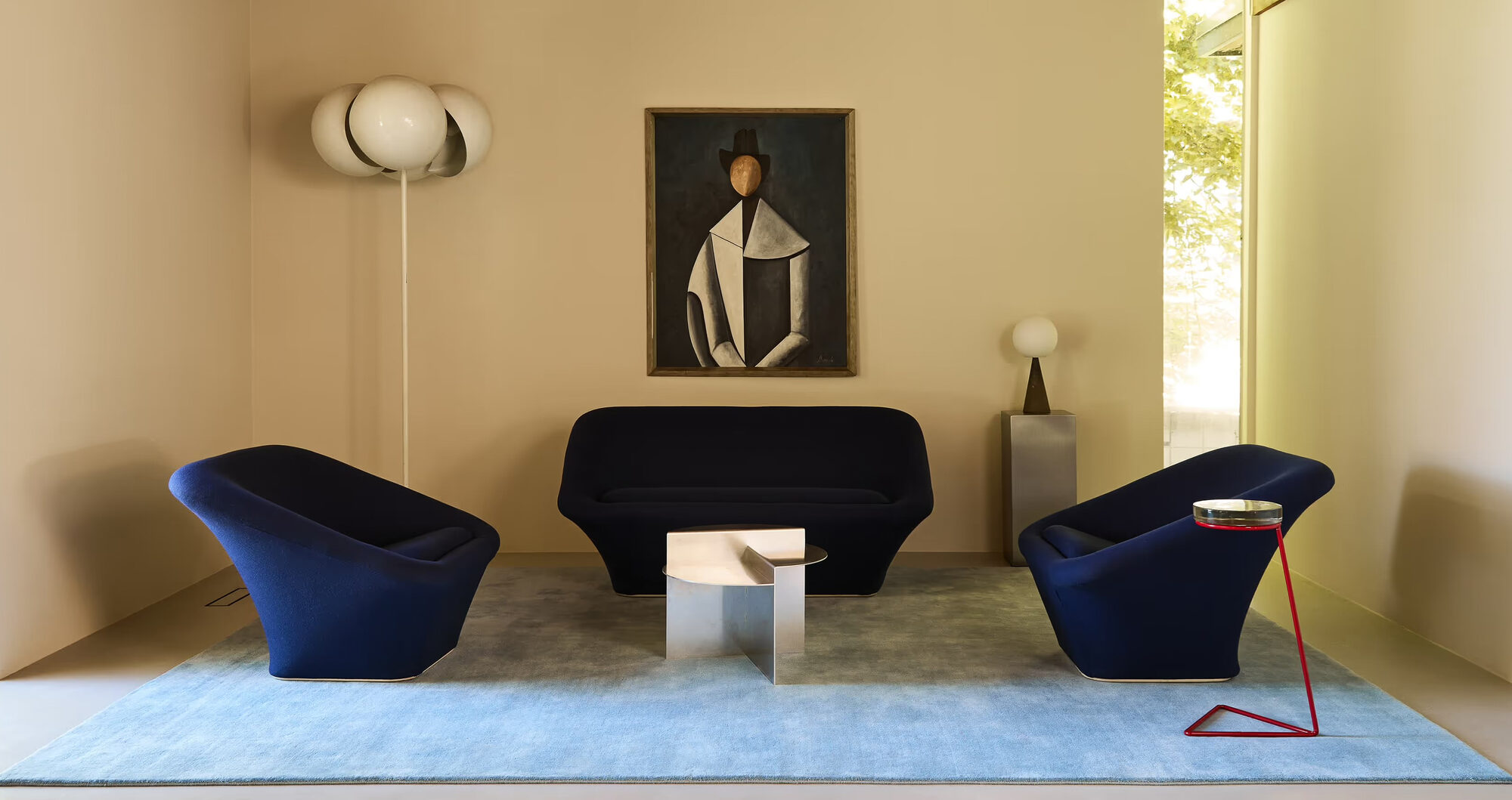Elegant living room with navy velvet sofa and sky blue rug