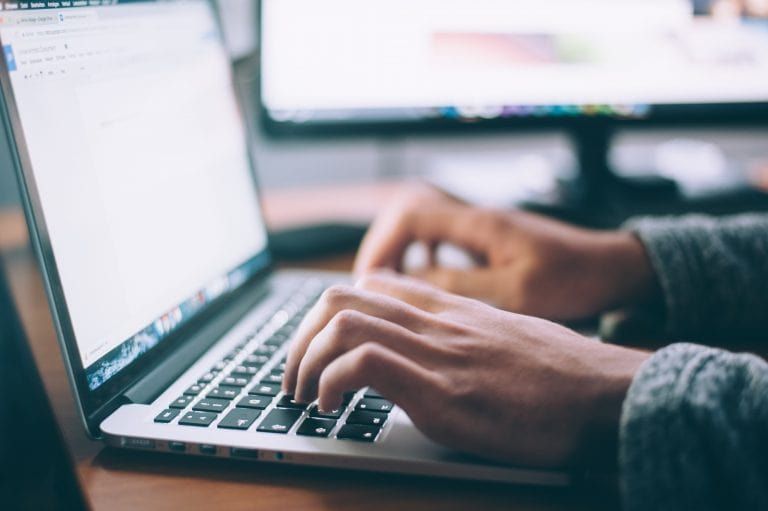 Person schreibt auf dem Laptop